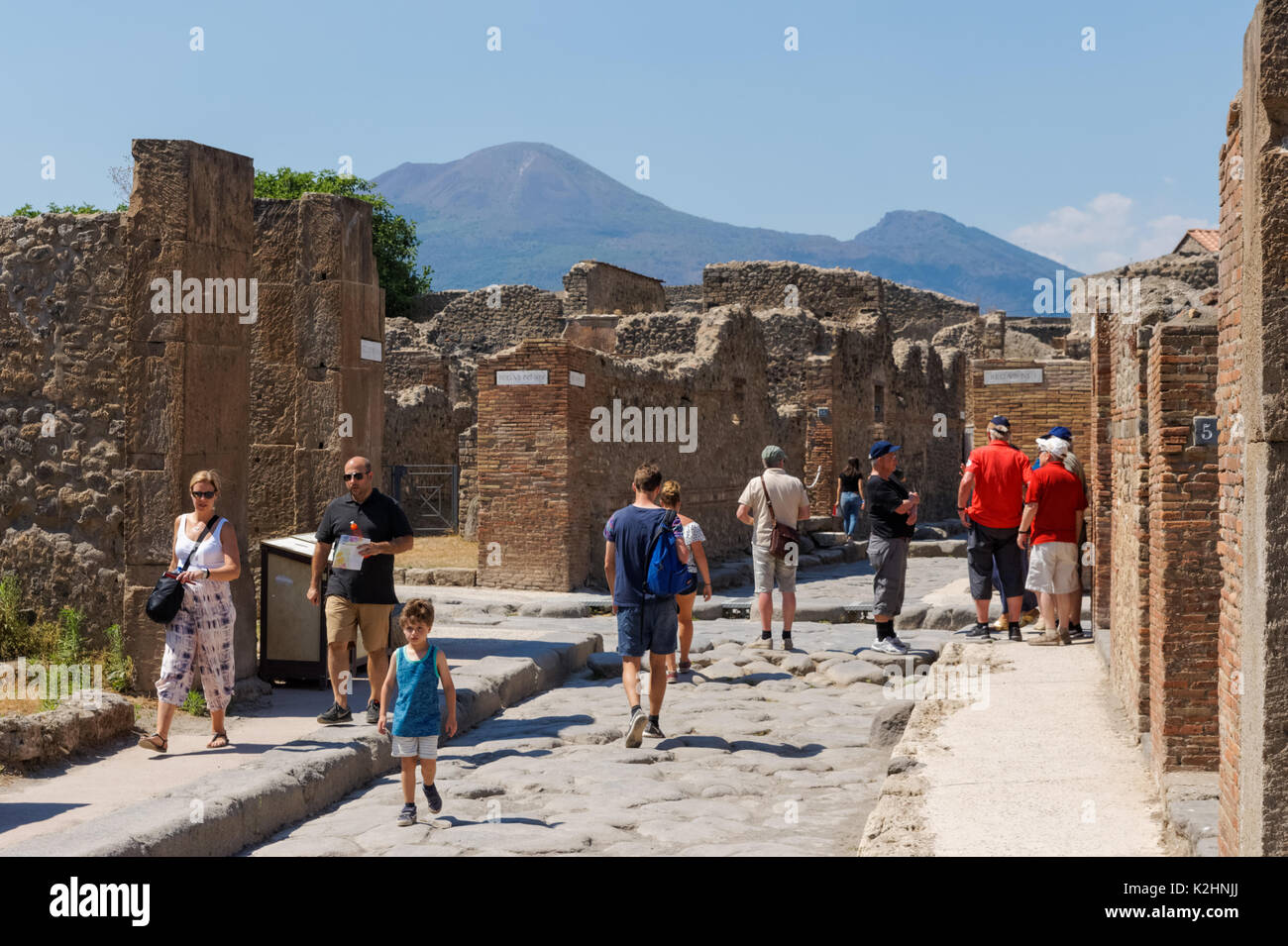 Tourists visiting Roman ruins of Pompeii with Mount Vesuvius in the background, Italy Stock Photo