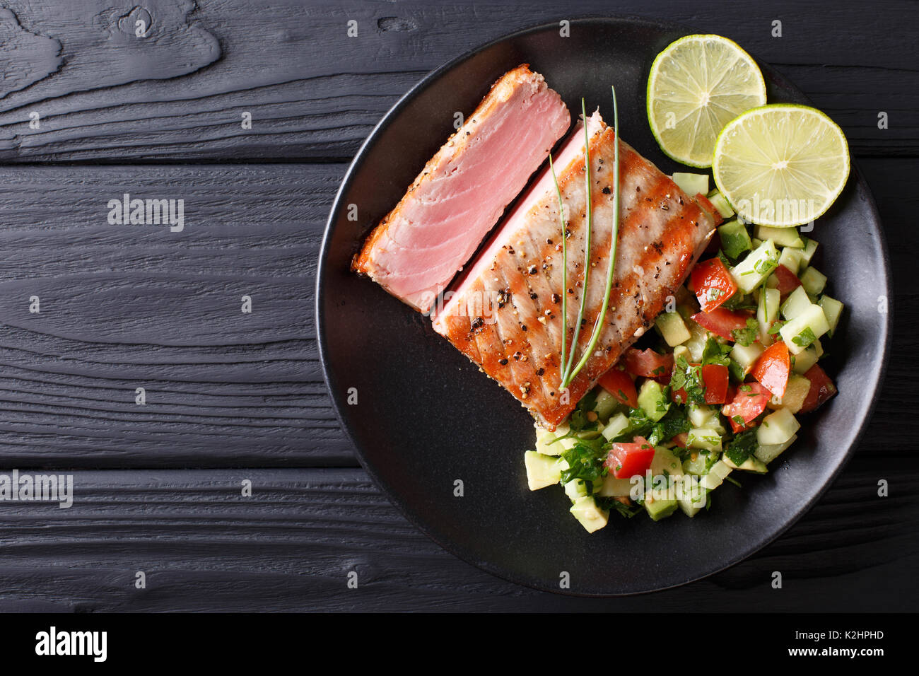 Freshly cooked grilled tuna steak with avocado cucumber salsa closeup
