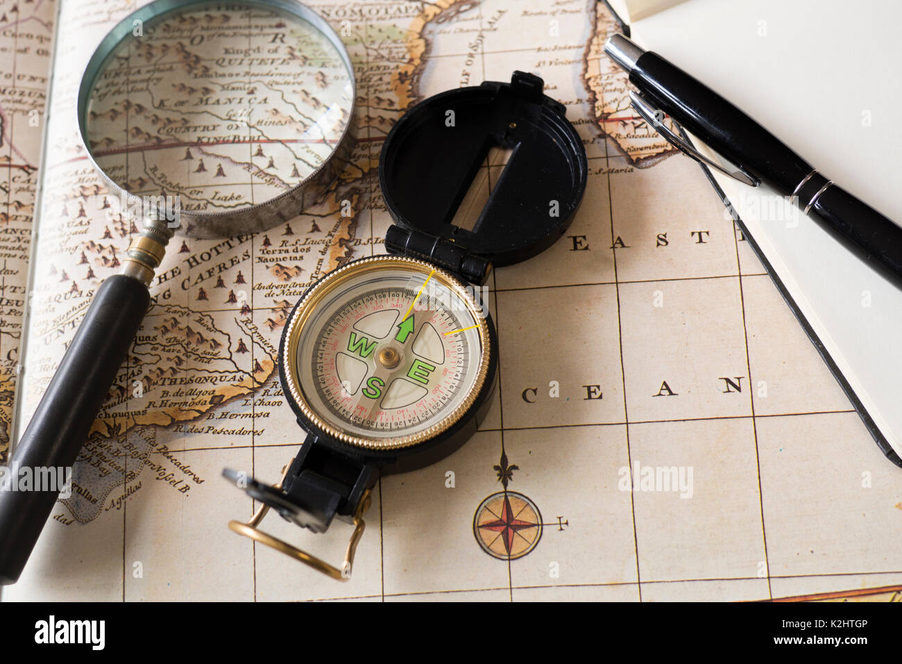 Compass and magnifying glass on old map Stock Photo - Alamy