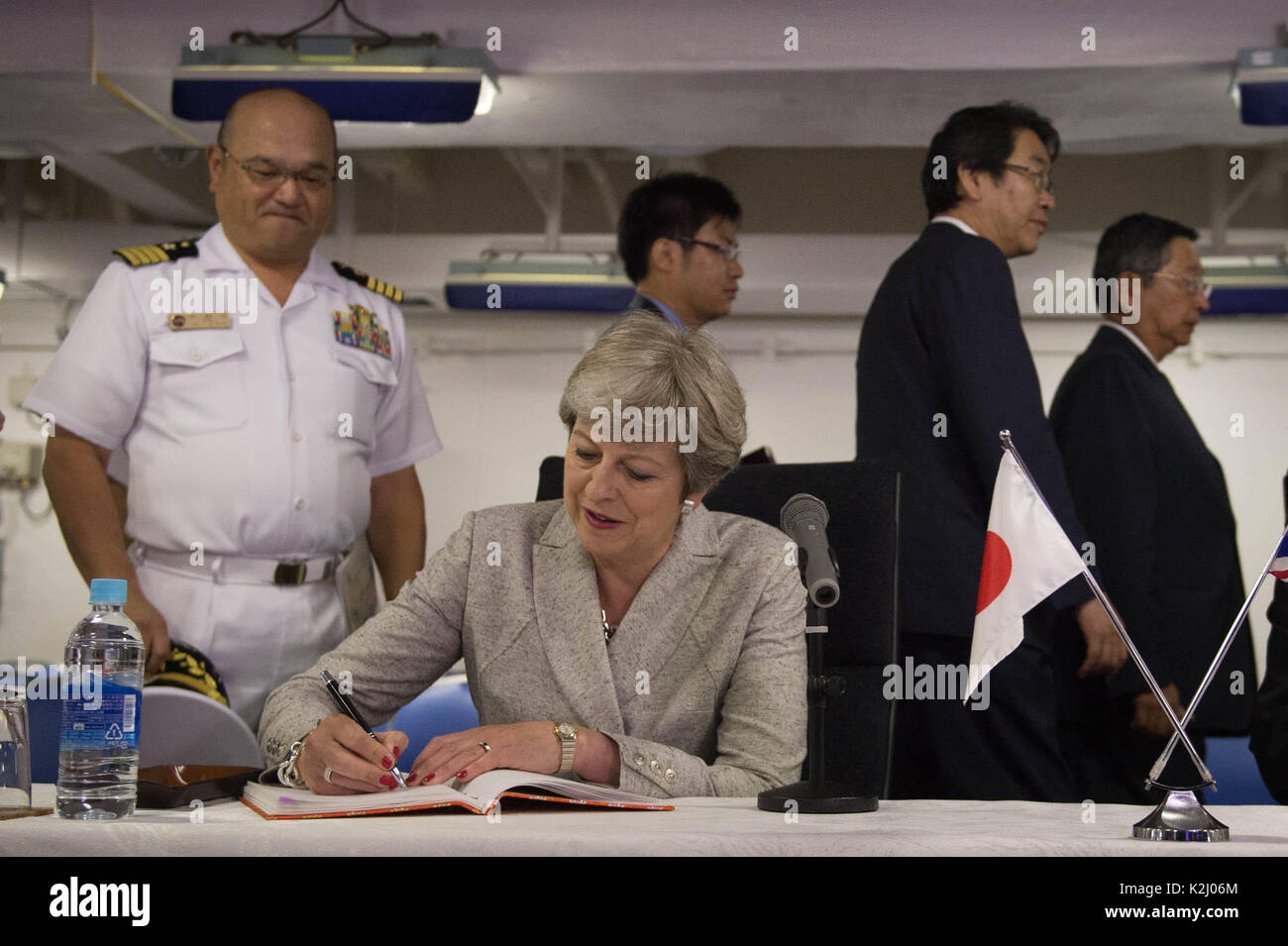 Prime Minister Theresa May signs a visitor's book after meeting crew and naval personnel including those from the British Royal Navy on board the Japanese aircraft carrier, J.S. Izumo at Yokosuka Naval Base near Tokyo. Stock Photo