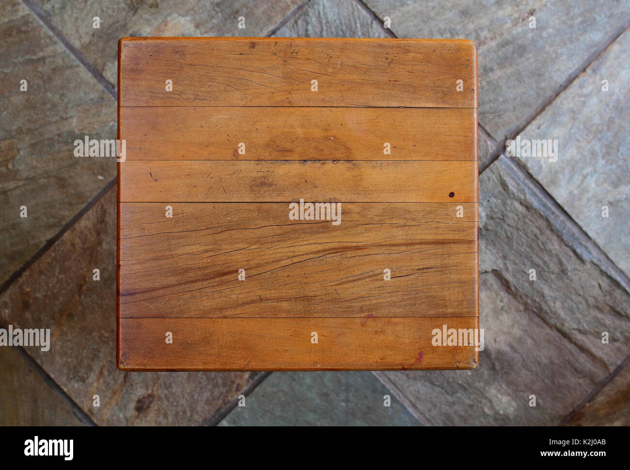 A weatherbeaten and worn yellow wood table top viewed from directly