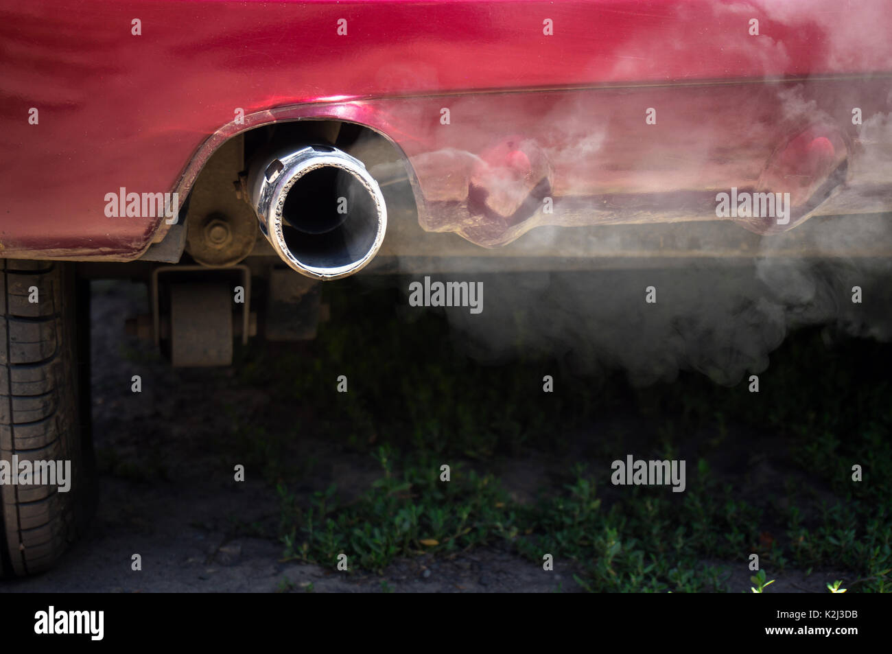 White smoke from the exhaust pipe of the car. Urban pollution exhaust