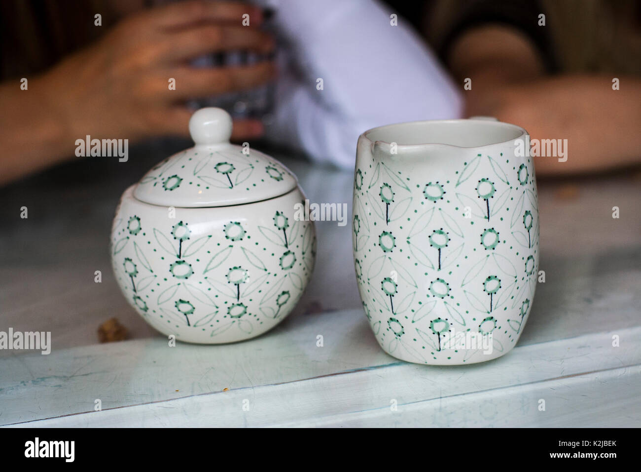 Pottery milk jug and sugar bowl with lid and contemporary floral design