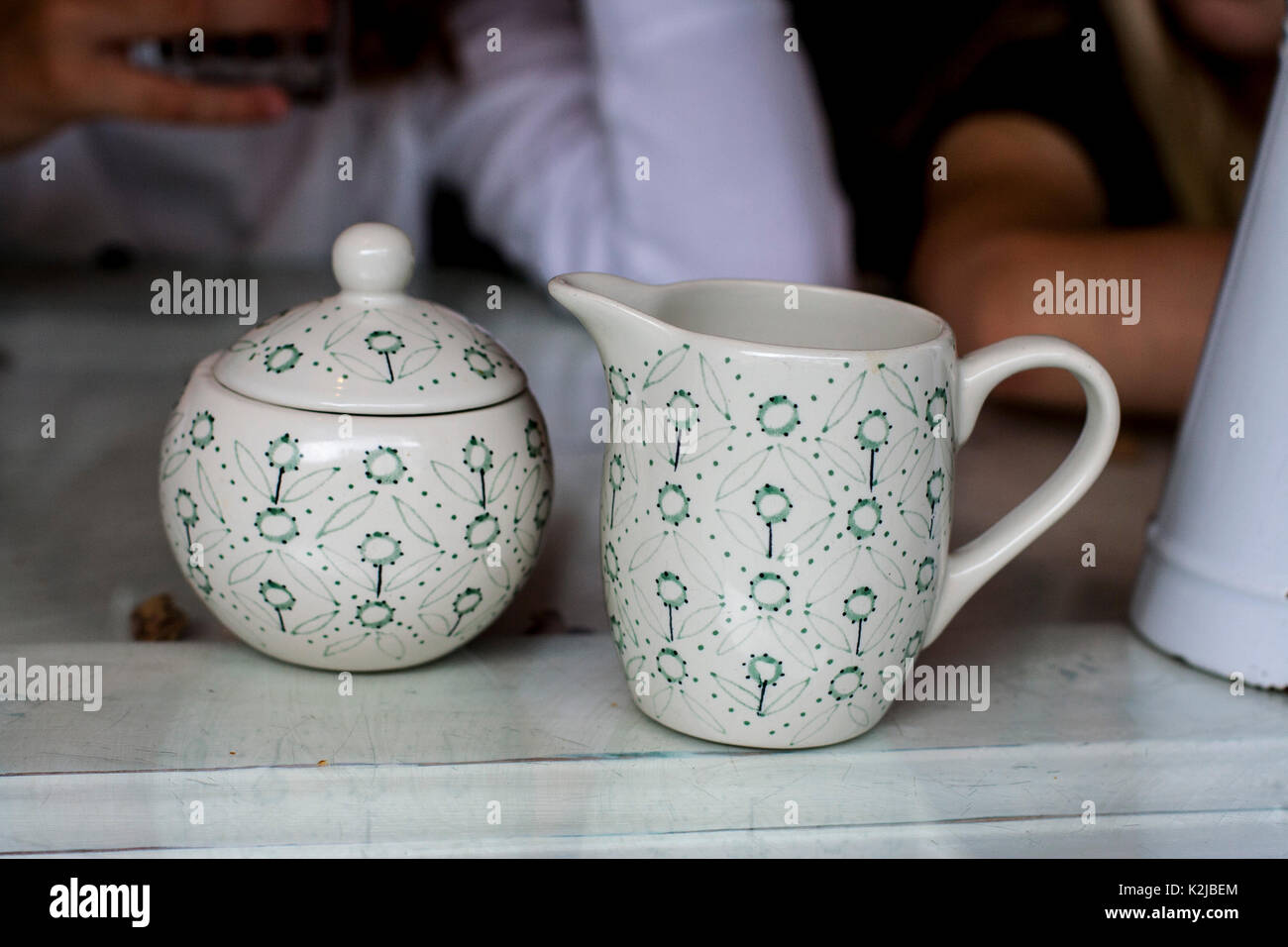 Pottery milk jug and sugar bowl with lid and contemporary floral design