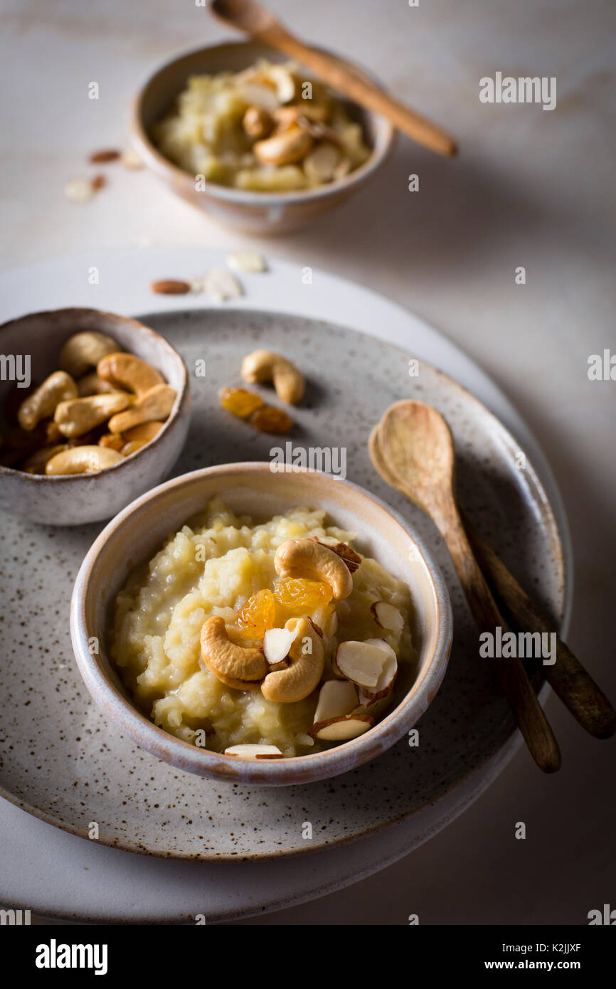 sweet pongal / rice lentil pudding topped with roasted nuts in individual serving bowls on a