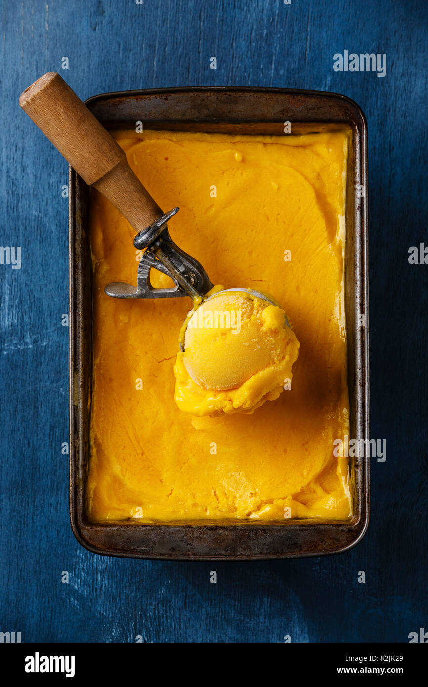 https://c8.alamy.com/comp/K2JK29/sorbet-mango-ice-cream-ball-in-scoop-on-blue-background-K2JK29.jpg