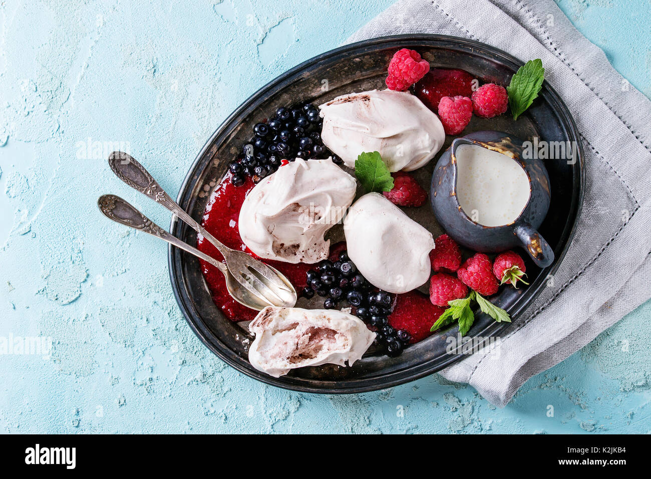 Traditional summer dessert Eton Mess. Meringue, jug of cream, berry jam