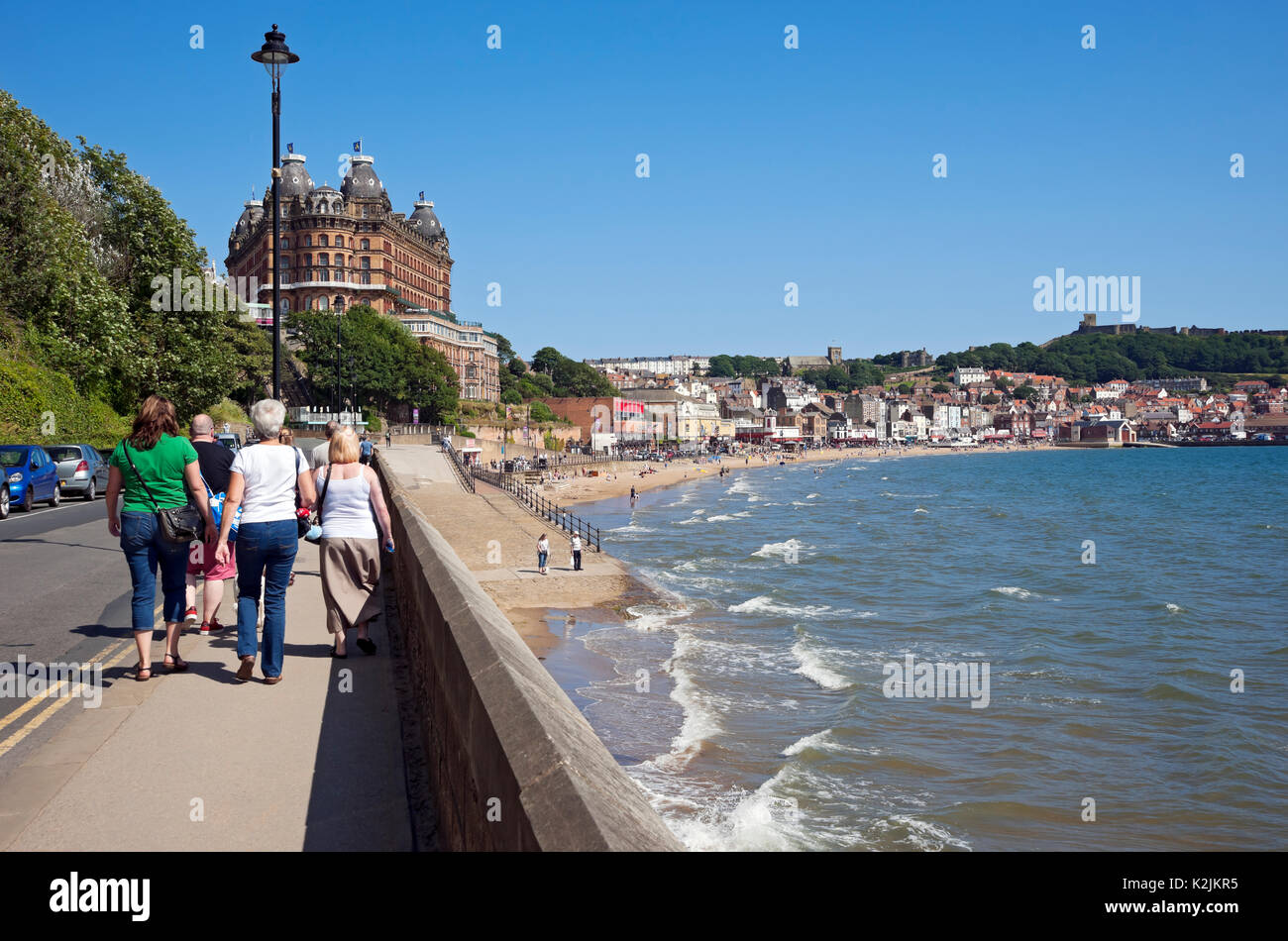 People tourists visitors walking along the seafront in summer Scarborough South Bay North Yorkshire England UK United Kingdom GB Great Britain Stock Photo