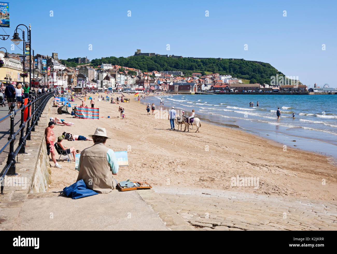 People tourists visitors on the beach in summer South Bay Scarborough North Yorkshire England UK United Kingdom GB Great Britain Stock Photo