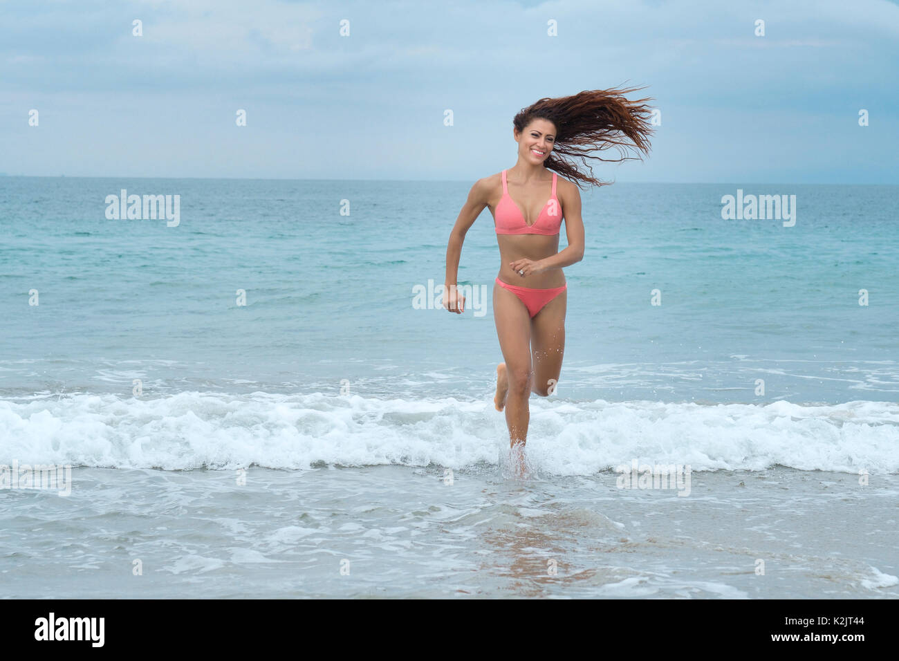 Attractive woman in bikini running at a beach Stock Photo