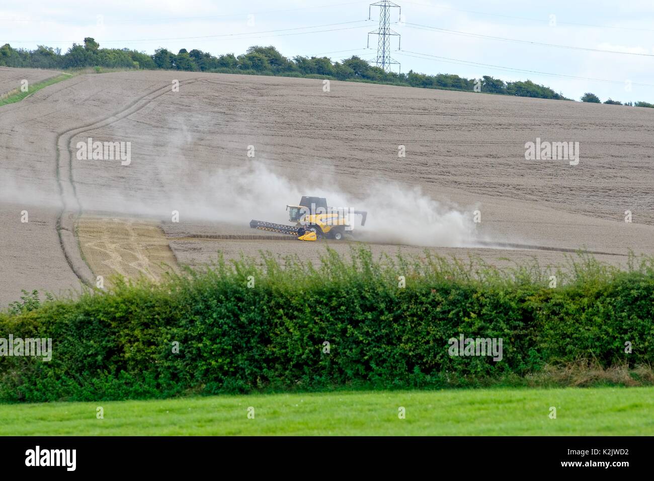 Combined harvester working in field On White Hill Kingsclere Hampshire UK Stock Photo