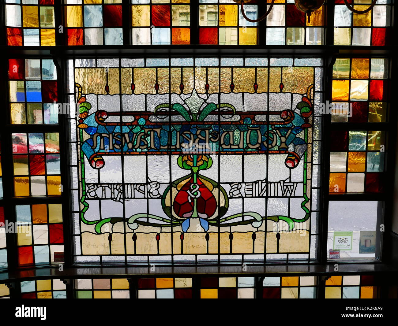 Stained glass window of the Old Bell Tavern, Fleet Street, London EC4. The picture is taken from inside the pub so the lettering appears in reverse. Stock Photo