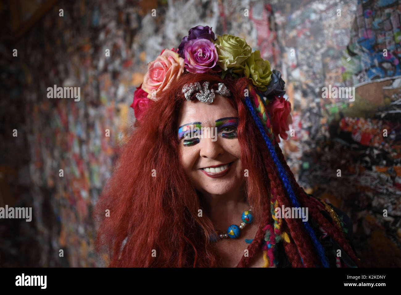 Cologne, Germany. 31st Aug, 2017. Muse Elke Koska stands in the 'Save The World' Hotel by performance artist HA Schult at the Rhine river in Cologne, Germany, 31 August 2017. The sculpture is an accessible house made of and decorated with trash. Photo: Henning Kaiser/dpa/Alamy Live News Stock Photo