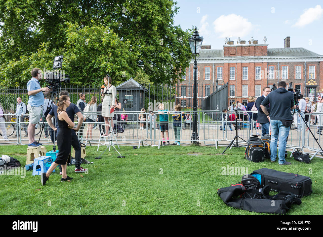 Well wishers, photographers and news crews jostle outside the gates of Kensington Palace to commemorate and pay tribute to Princess Diana, twenty years after her death. Stock Photo