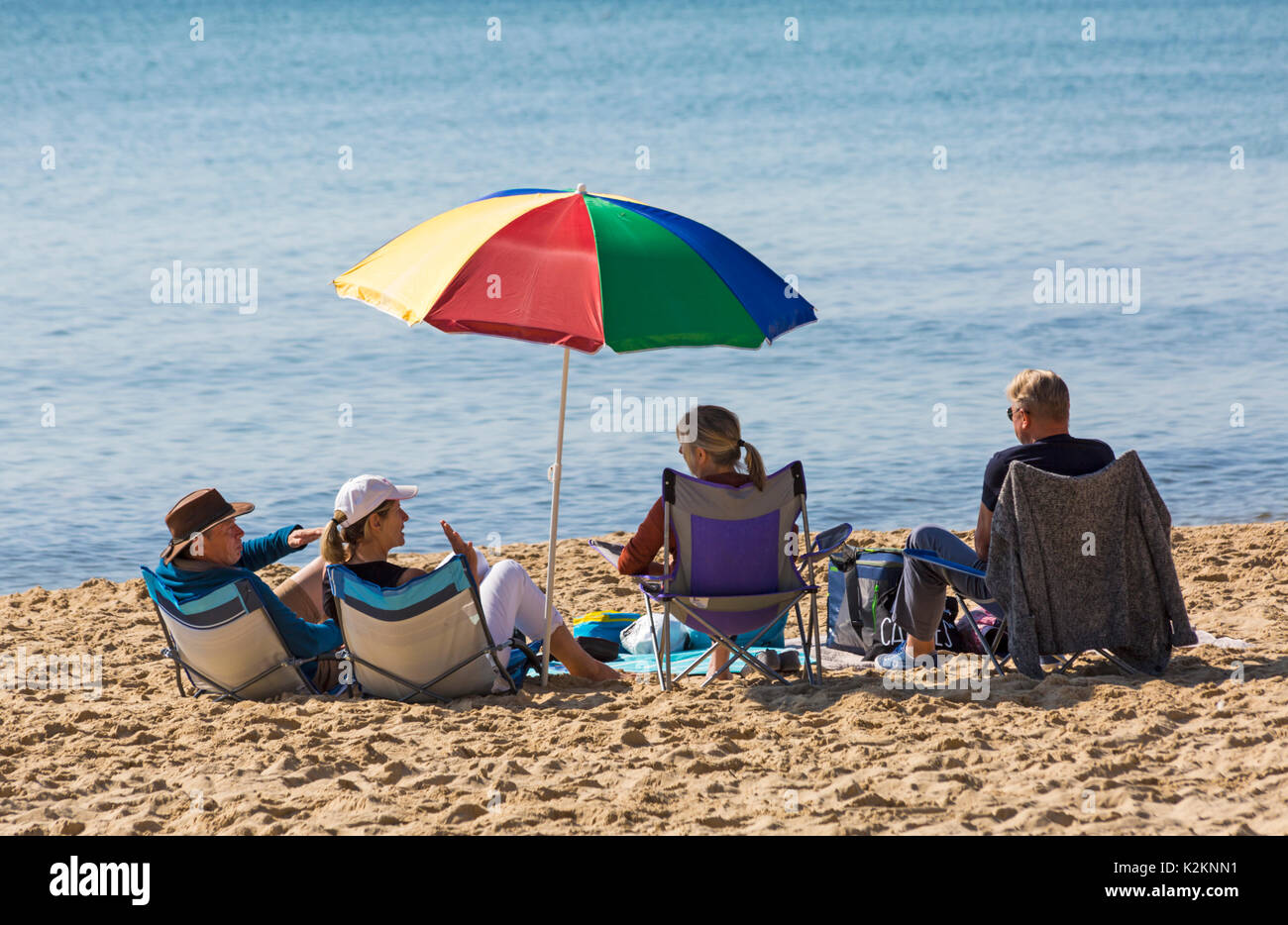 Bournemouth, Dorset, UK. 1st Sep, 2017. UK weather: lovely warm sunny day at Bournemouth beach on the South Coast. Beachgoers sit in chairs under colourful parasol.  Credit: Carolyn Jenkins/Alamy Live News Stock Photo