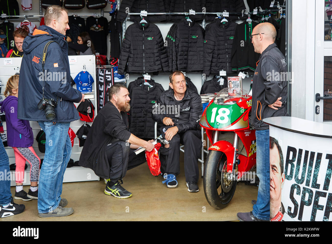 Injured John McGuinness signs copies of his book for fans at the 2017 Manx Grand Prix Stock Photo