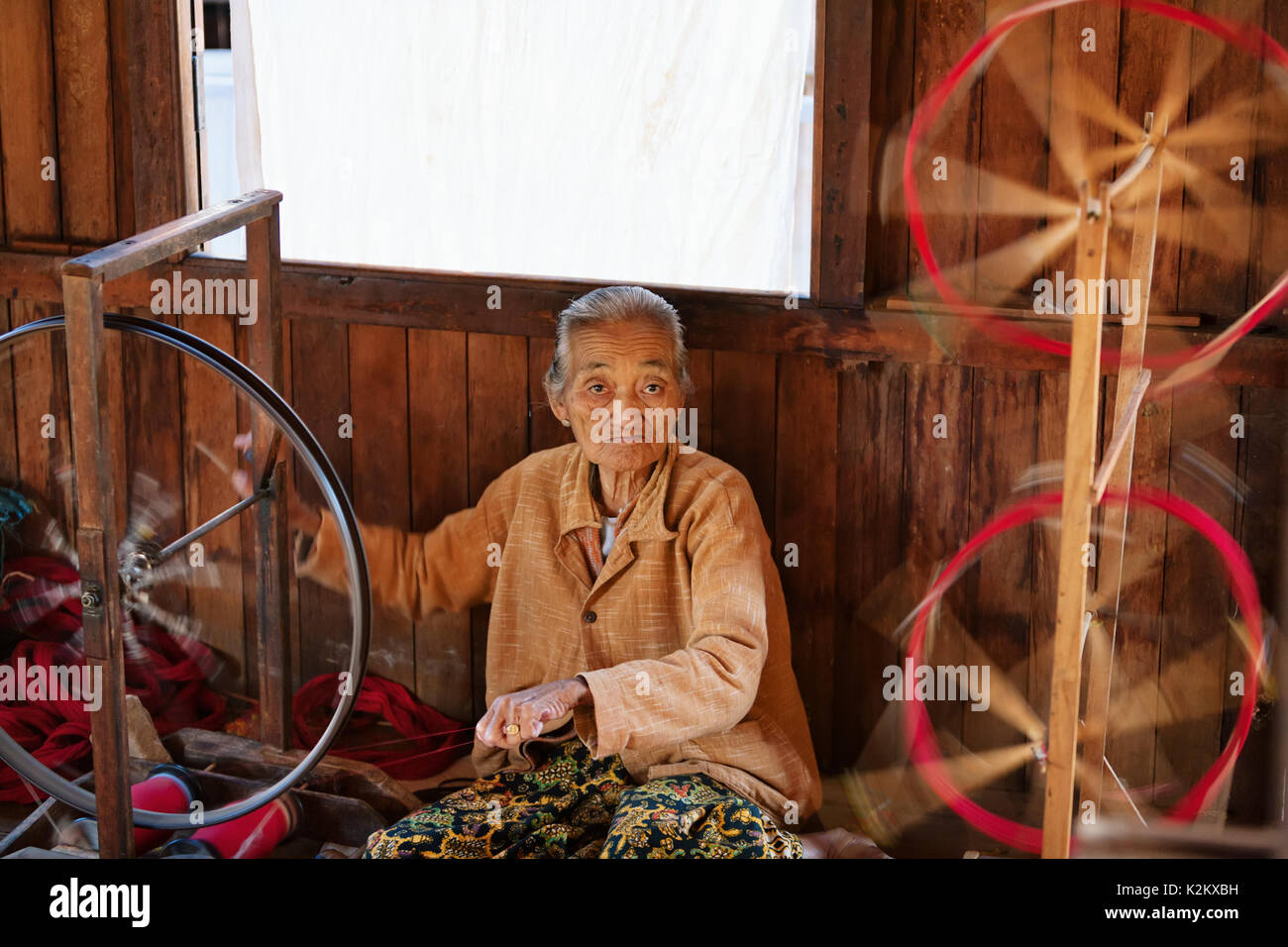 Inle Lake, Myanmar - January 04, 2007: Old woman of Intha people working at home in village on Inle lake in Shan state, spinning yarn by hand. Stock Photo