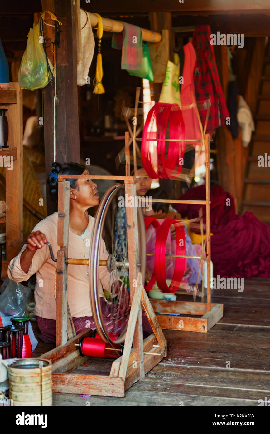 Inle Lake, Myanmar - January 04, 2007: Old woman of Intha people working at home in village on Inle lake in Shan state, spinning yarn by hand for trad Stock Photo