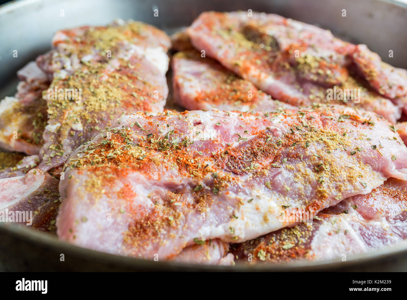 Uncooked pork steaks with seasoning Stock Photo