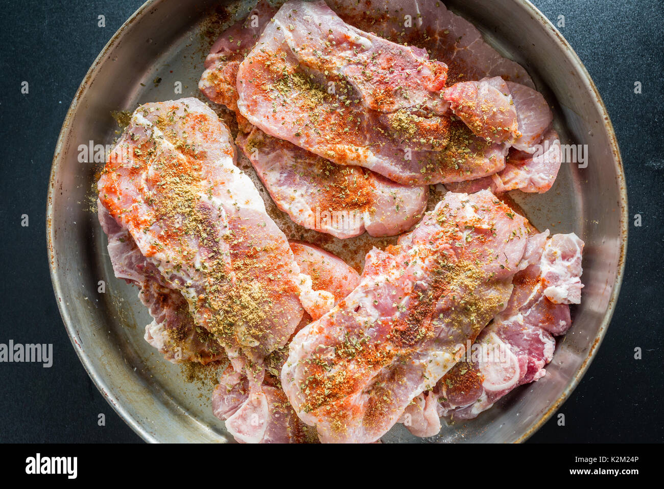 Uncooked pork steaks with seasoning Stock Photo