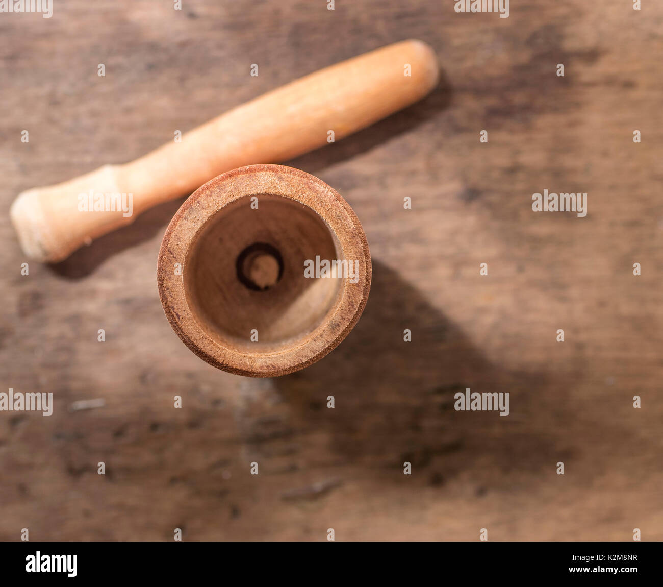 Wood Mortar and pestle on a wooden background and surface, top view, kitchen and cooking utensil device, for mixing and griding Stock Photo