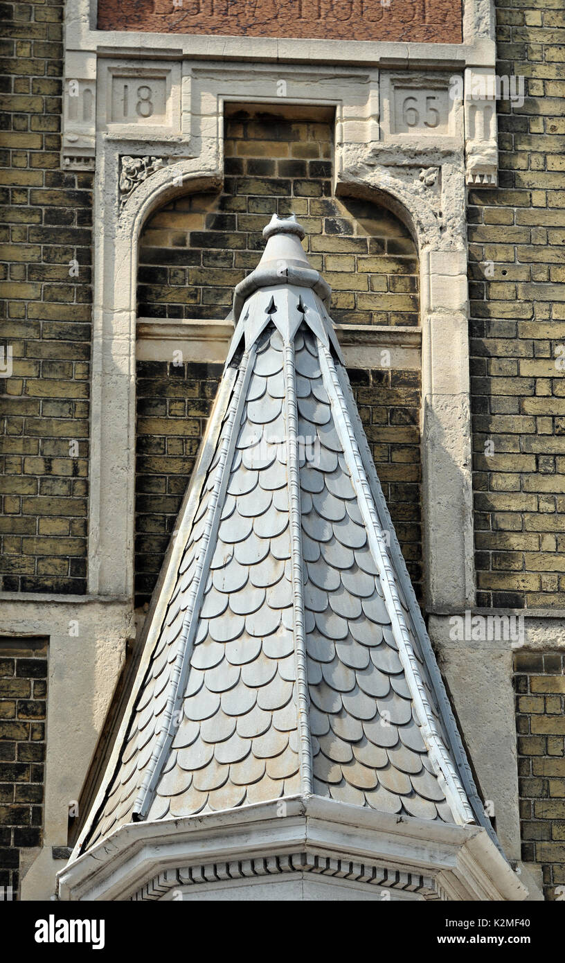 A Victorian or Edwardian interesting minaret roof or steeple on an old period building strange architectural designs topped with a finial and cap Stock Photo