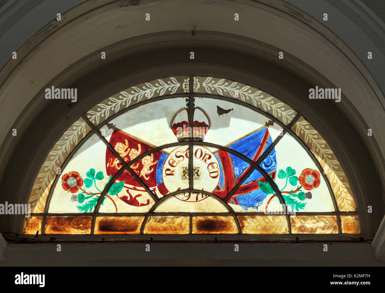 a beautiful and colourful patriotic british national pride stained glass window with the royal coat of arms and military insignia badges and flags Stock Photo