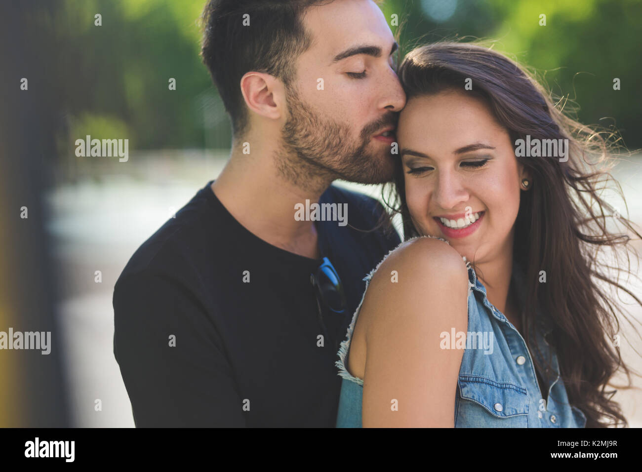 Portrait of handsome man kissing on head happy girlfriend Stock Photo