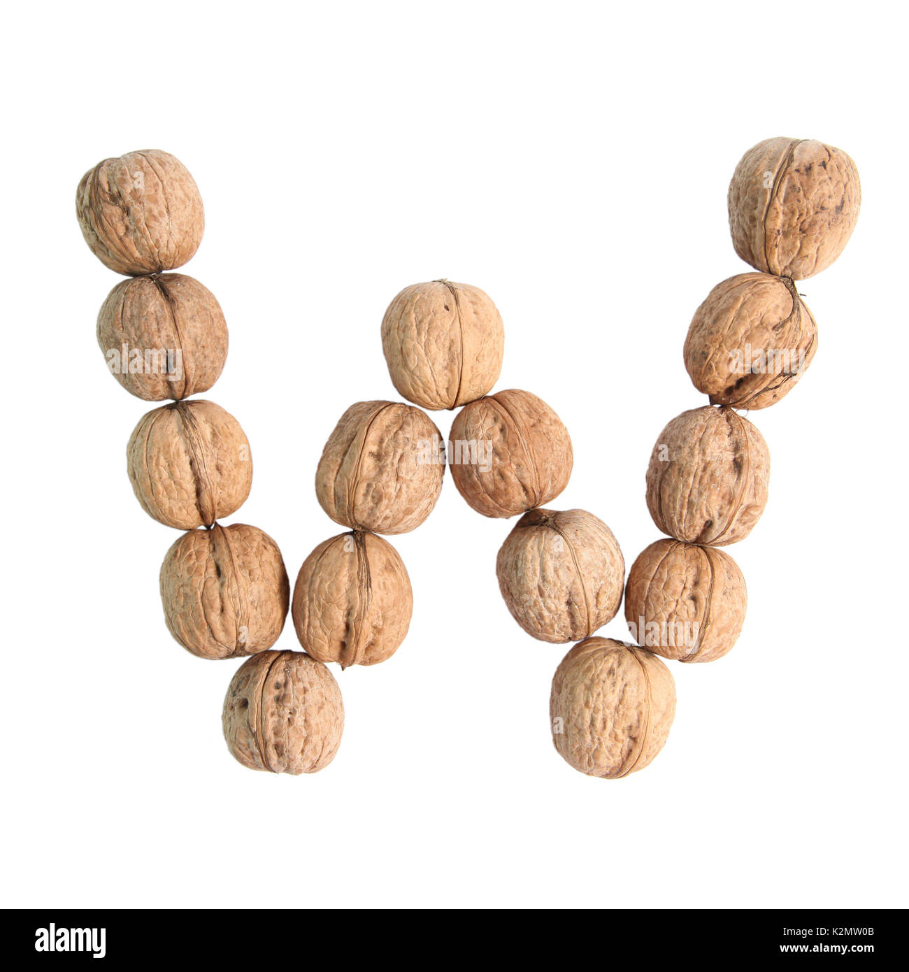 The group of walnuts on white background, making letter W. Studio shot Stock Photo