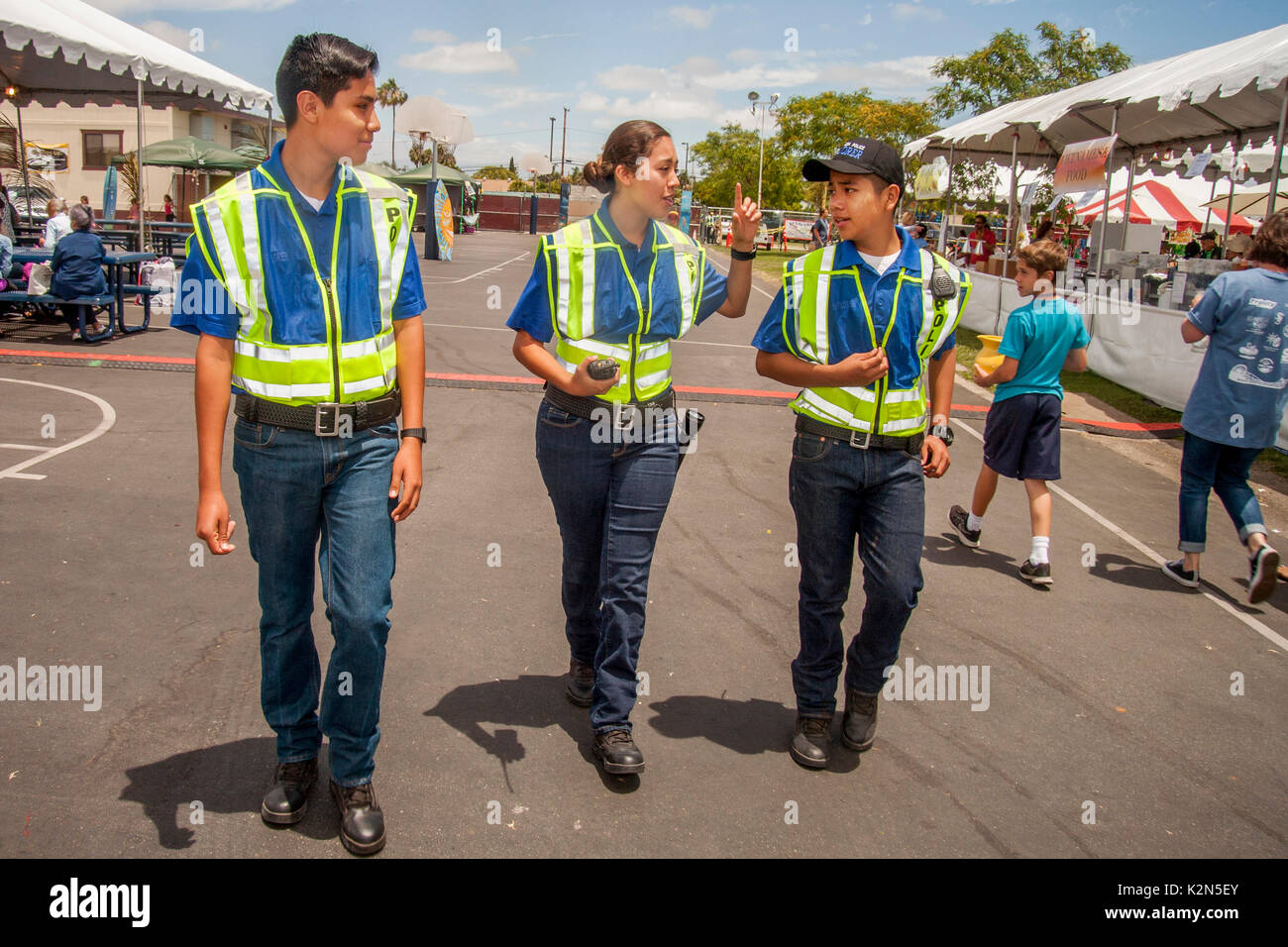 Male and female teen Hispanic Explorer Scouts serve as auxiliary police at a street fair in Costa Mesa, CA. Stock Photo