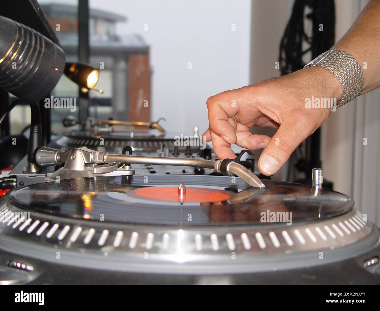 DJ placing needle on vinyl record using decks and mixer Stock Photo Alamy