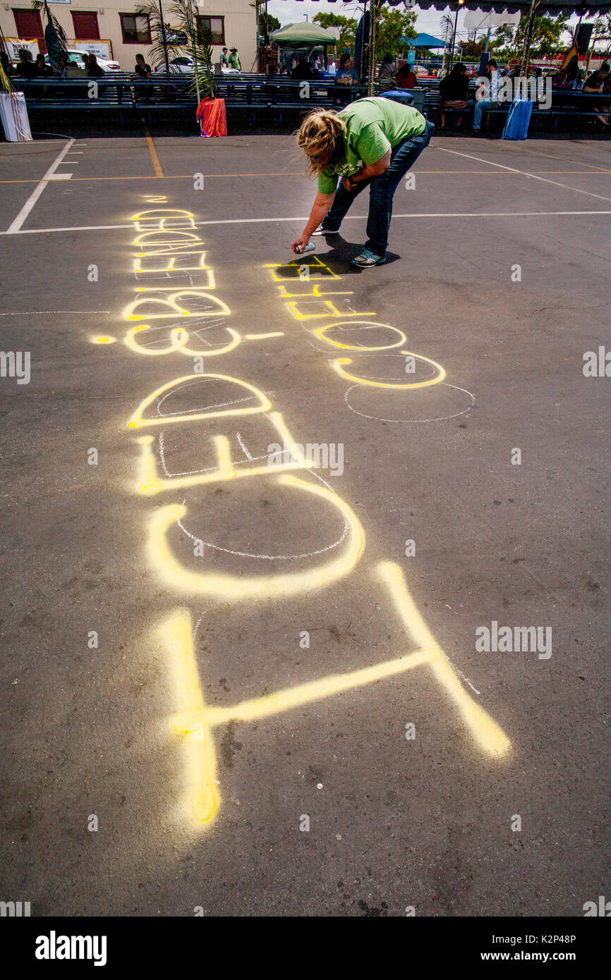 Using yellow spray paint, a young woman announces the availability of
