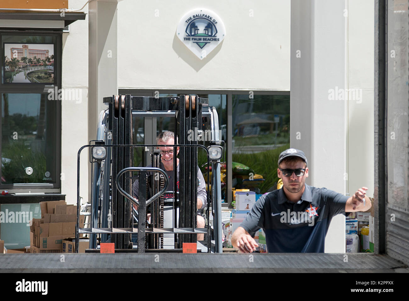 West Palm Beach, Florida, USA. 31st Aug, 2017. Ballpark Director of Operations Thomas Bell, left, operates a forklift as Greg Sargent, 27, climbs into one of the 53-foot-long trailers that will carry supplies for Houston parked at the Ballpark of the Palm Beaches in West Palm Beach, Fla., on Thursday, August 31, 2017. The Houston Astros baseball team is praising Palm Beach County residents for a greater-than-expected response to the team's request for donations to help victims of Hurricane Harvey. The unexpected response has prompted the team to send in a second truck to carry supplies t Stock Photo