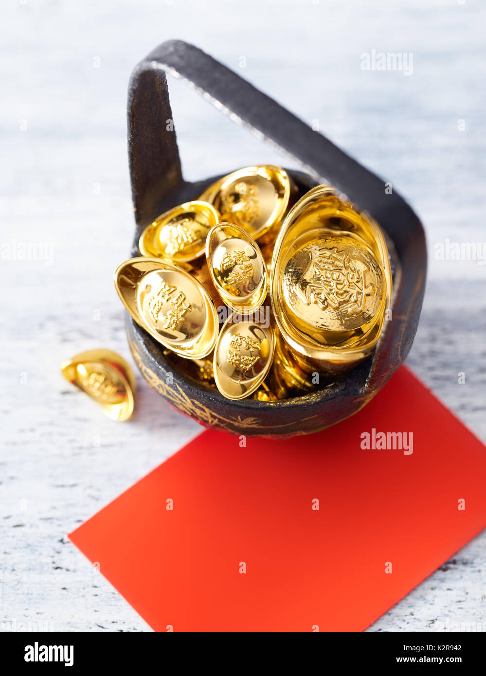 Chinese New Year - Gold sycee and red card on white painted wood table Stock Photo