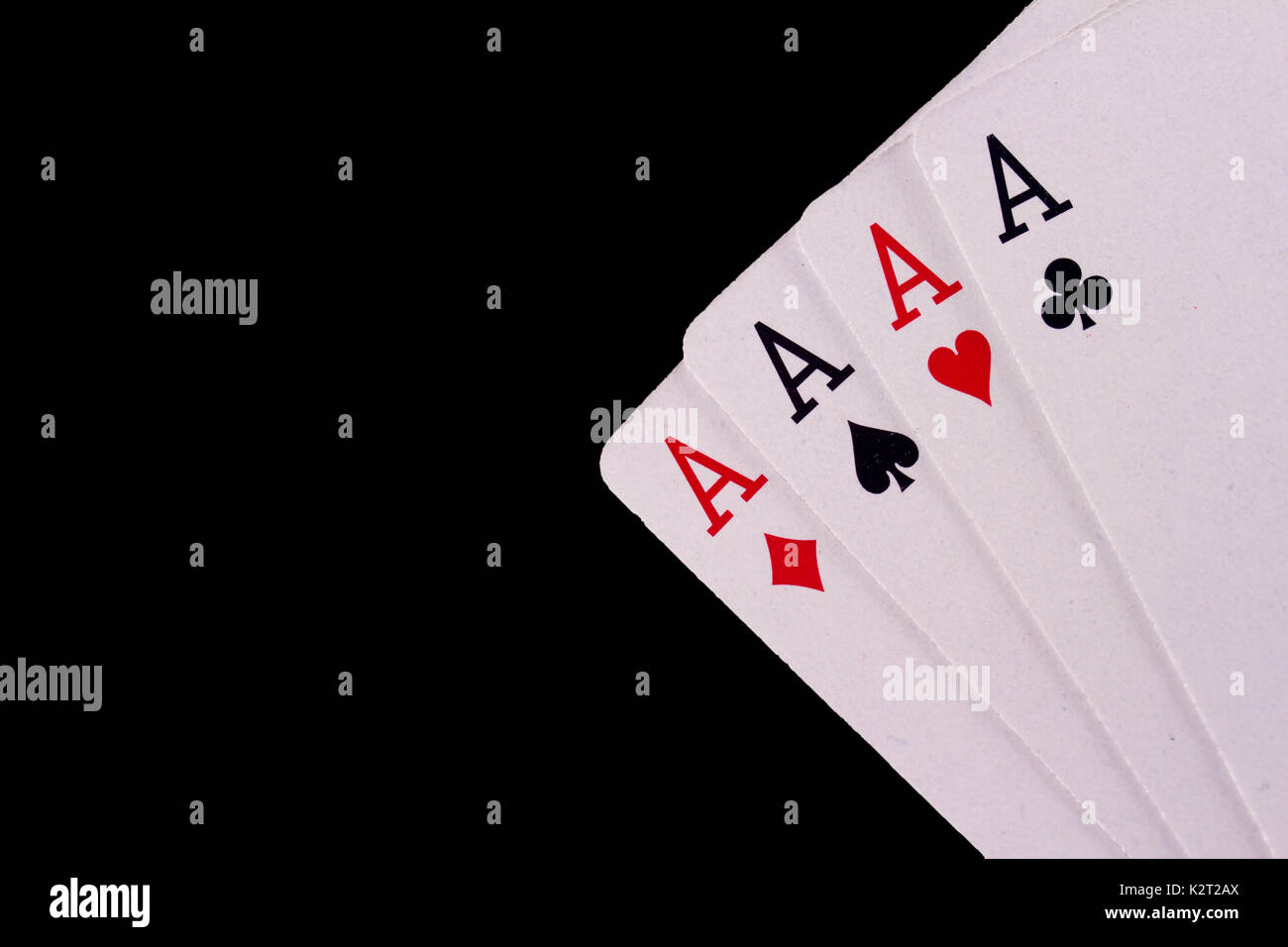 Four Aces playing cards set against a black background. Stock Photo