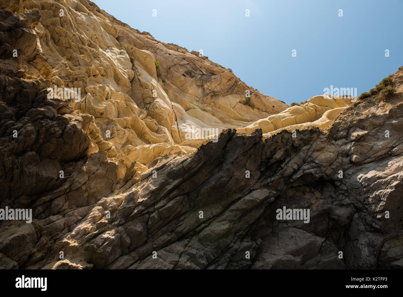 Cracked, fragmented limestone rock against blue sky. Geology pattern Stock Photo