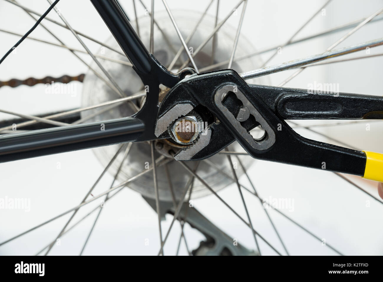 Portrait Of Young Man Tightening The Bolts Of Bicycle Seat With Spanner
