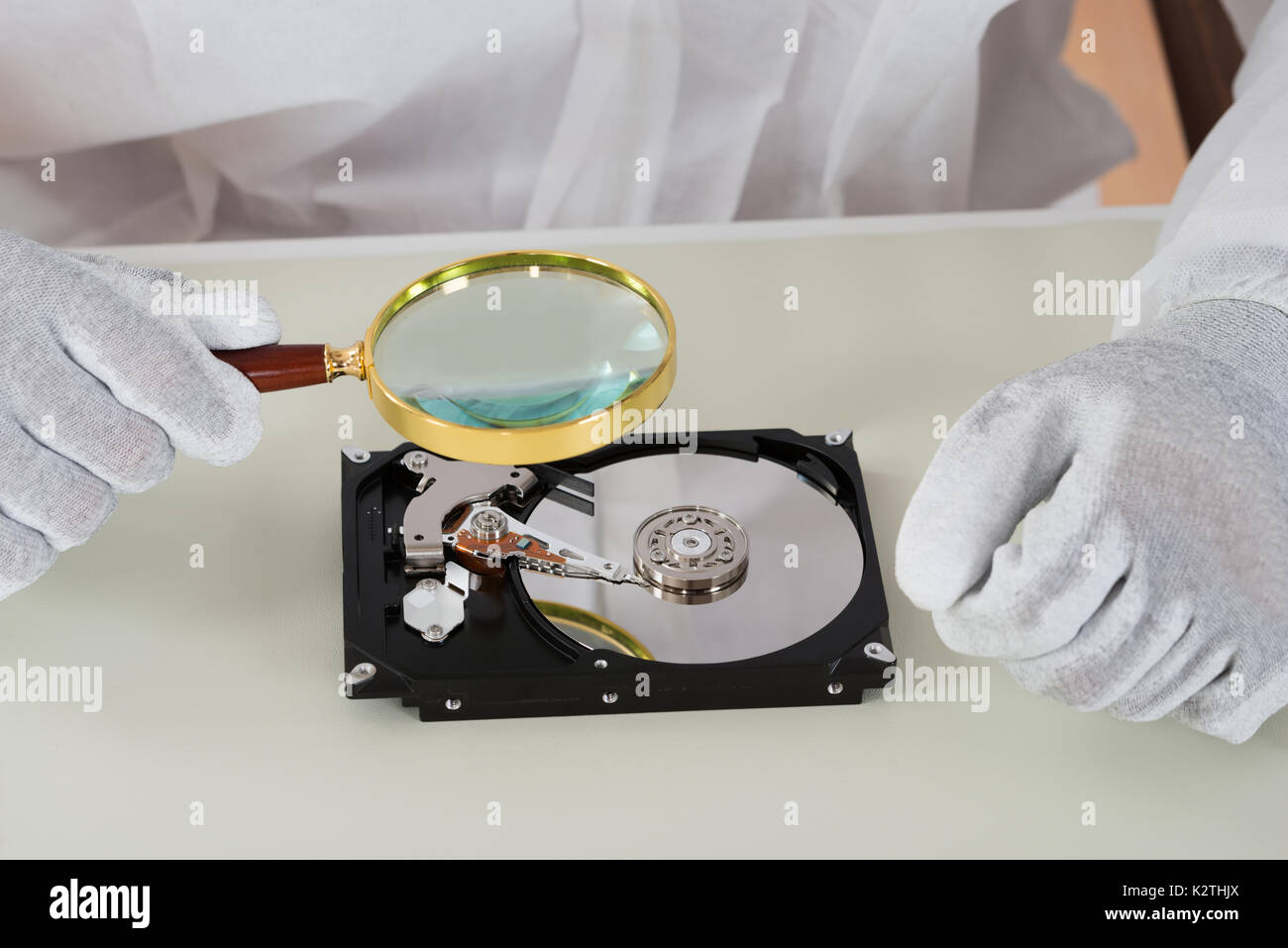 Close-up Of Person Holding Magnifying Glass Over Harddisk At Desk Stock ...
