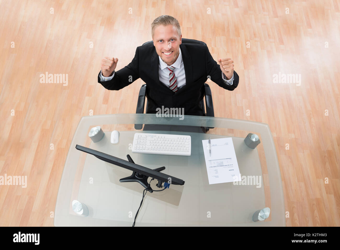 Young Happy Businessman Clenching His Fist At Workplace Stock Photo
