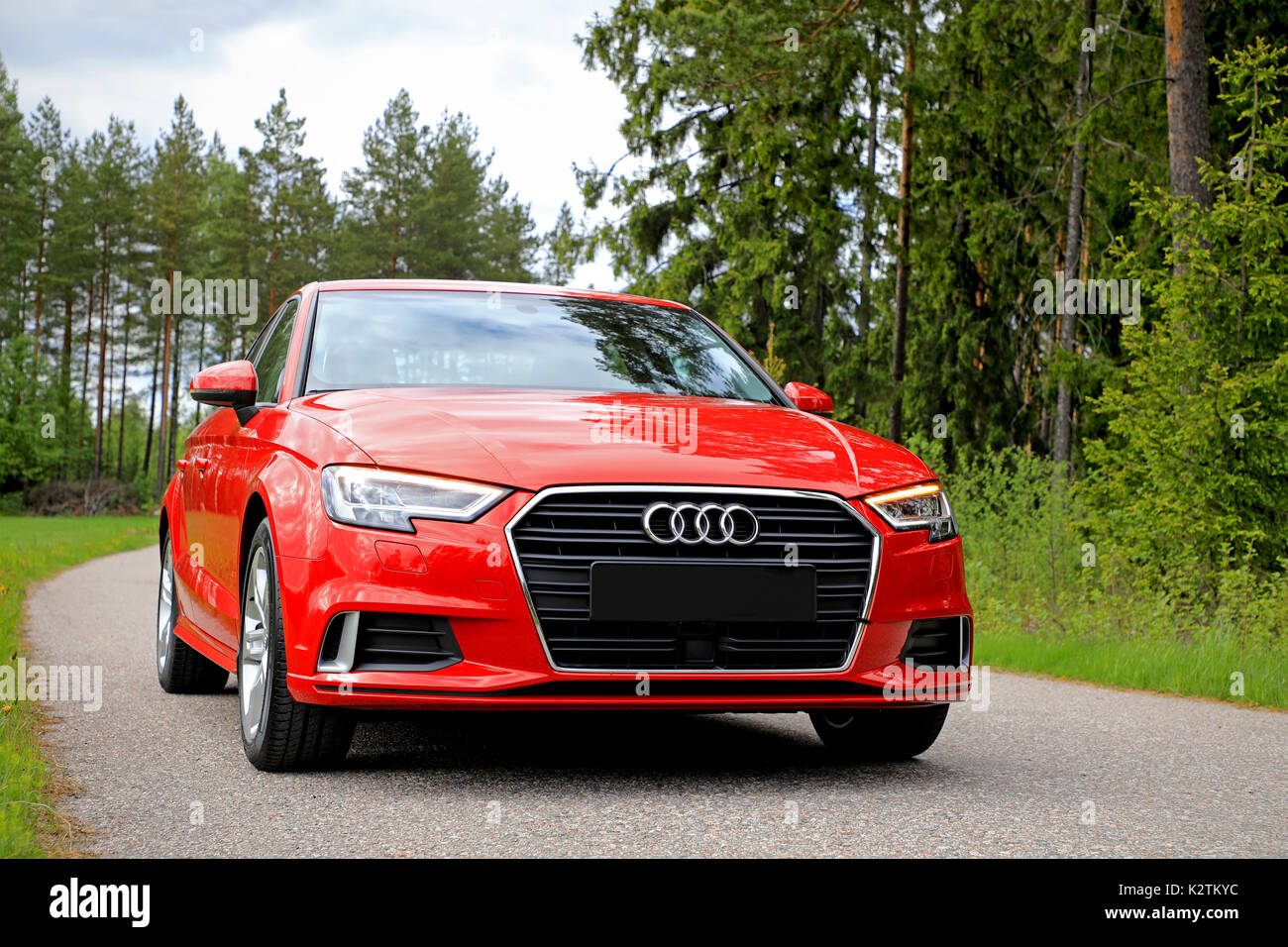 SALO, FINLAND - JUNE 2, 2017: New beautiful Tango red Audi A3 Sedan Business Sport 2017 parked on a small rural road flanked by forest in early summer Stock Photo
