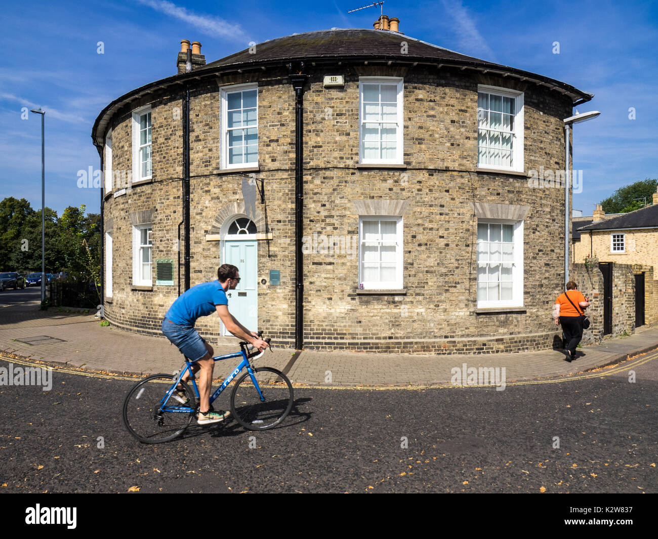 Round fronted house in Cambridge UK - a cyclist passes a round fronted building in New Square, Cambridge UK Stock Photo