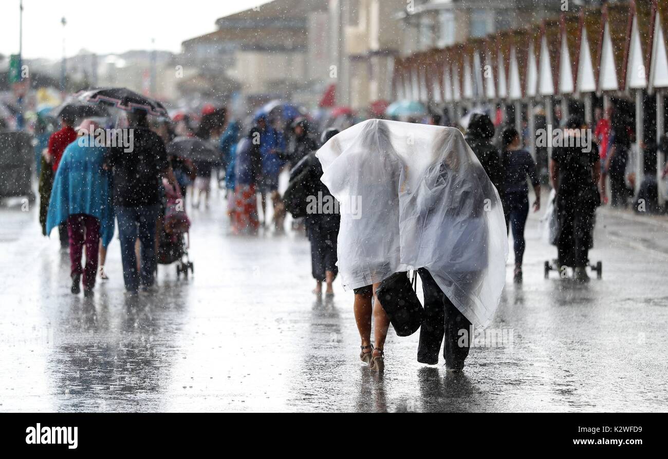 People get caught in a sudden downpour on Bournemouth beach during the ...