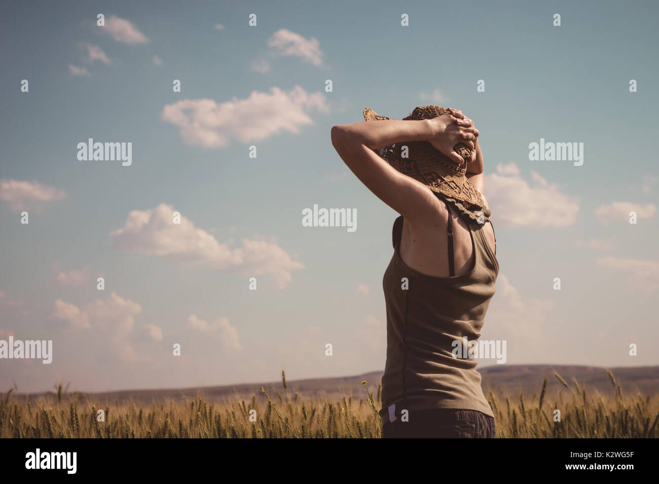 Caucasian woman  with hands behind head, staring at horizon on a summer day. Stock Photo