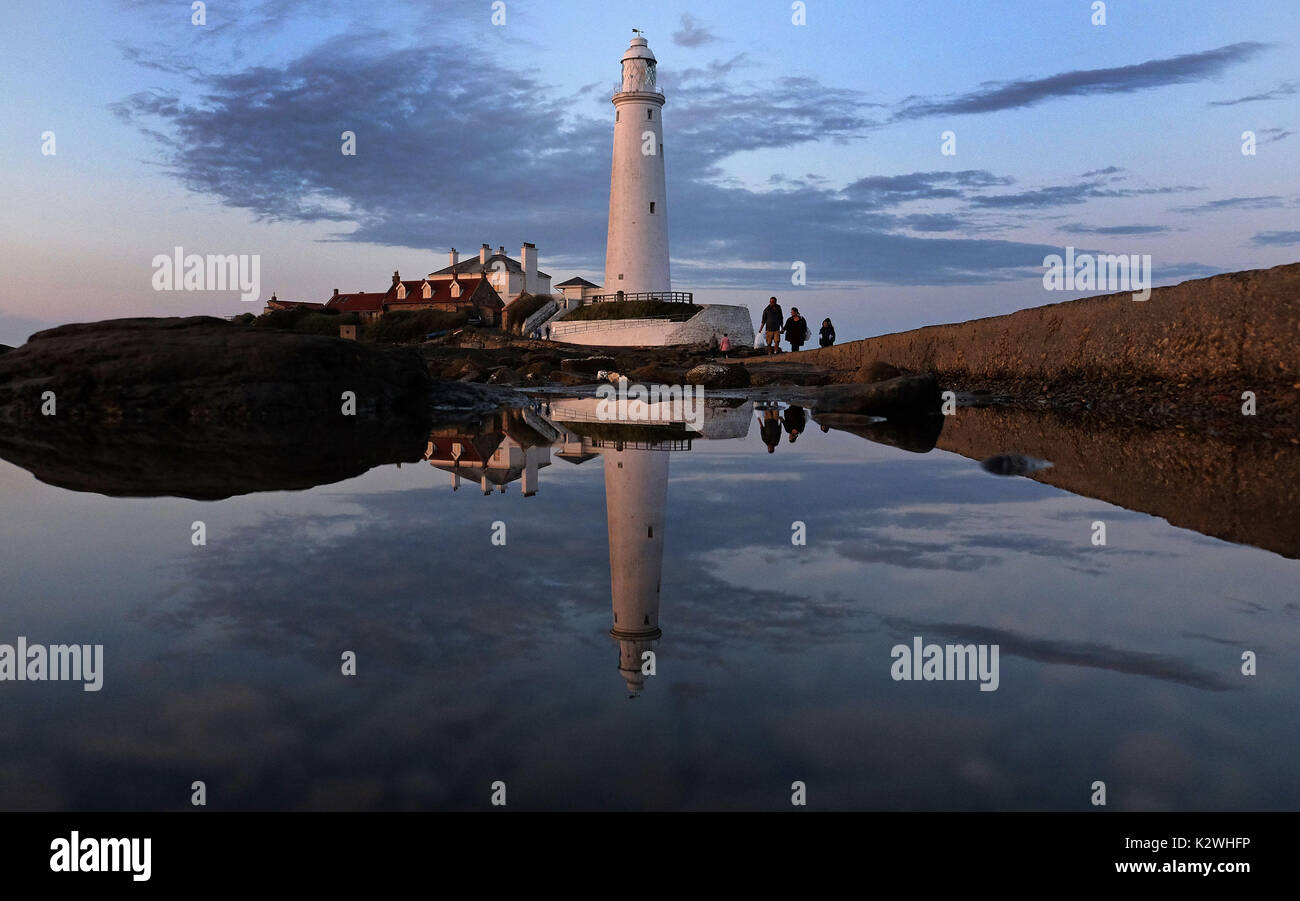 St Mary's Lightouse is reflected in Whitley Bay, North Tyneside, on the last day of meteorological summer. Stock Photo