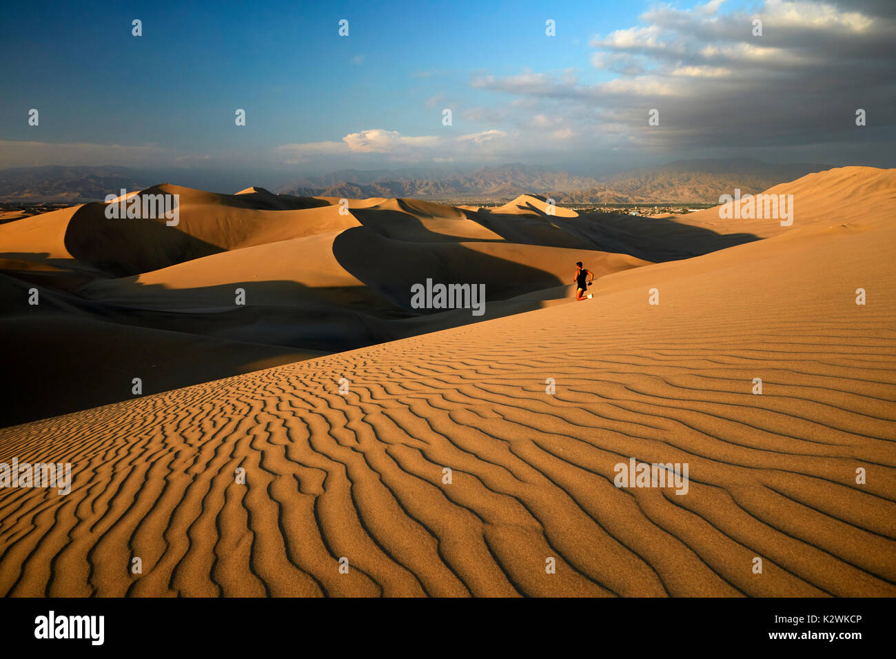 Runner on sand dunes in desert near Huacachina Oasis, Ica, Peru, South America Stock Photo