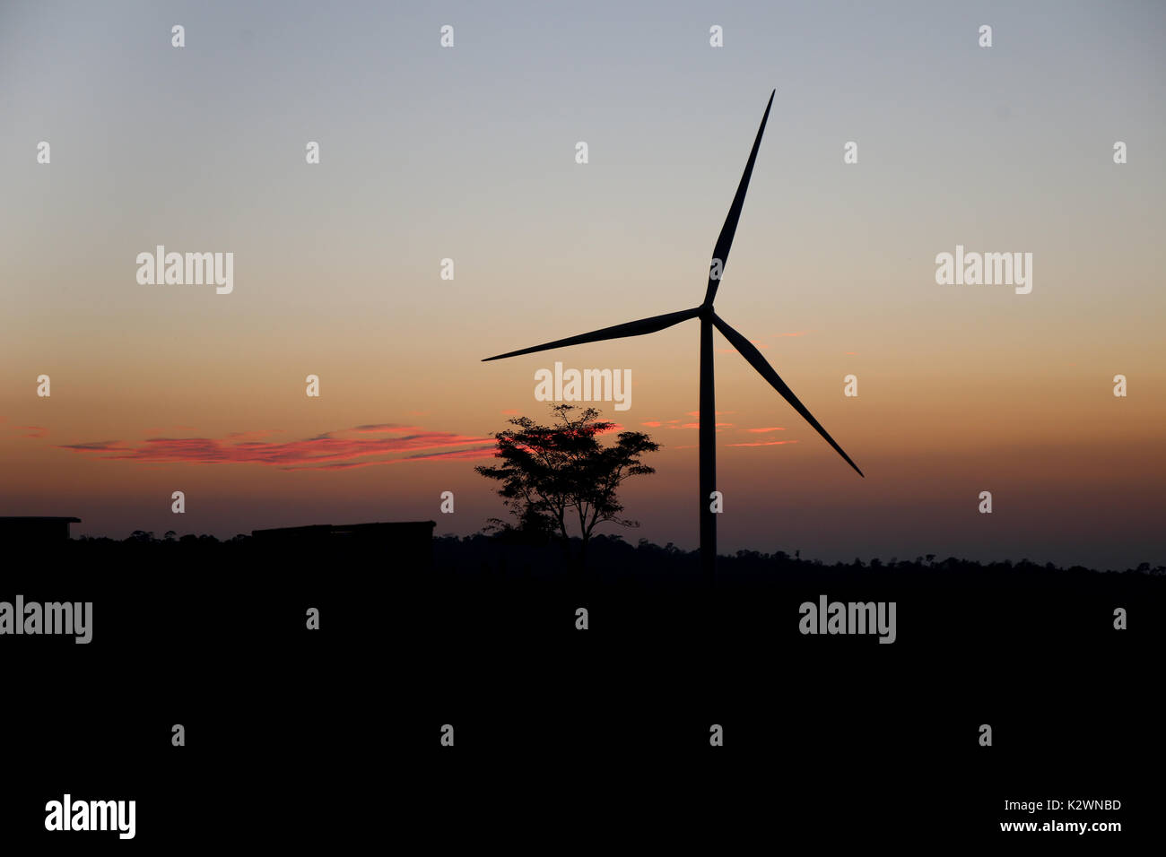 A solitary Wind Turbine silhouetted against a dramatic sunset sky ...
