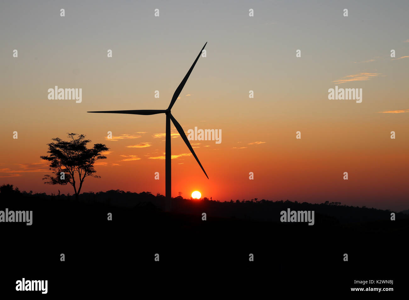 A solitary Wind Turbine silhouetted against a dramatic sunset sky ...