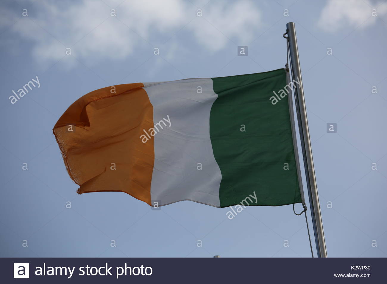The Irish triclour, flag of the Republic of Ireland, blowing in the wind in Dublin on a summer's day. Stock Photo