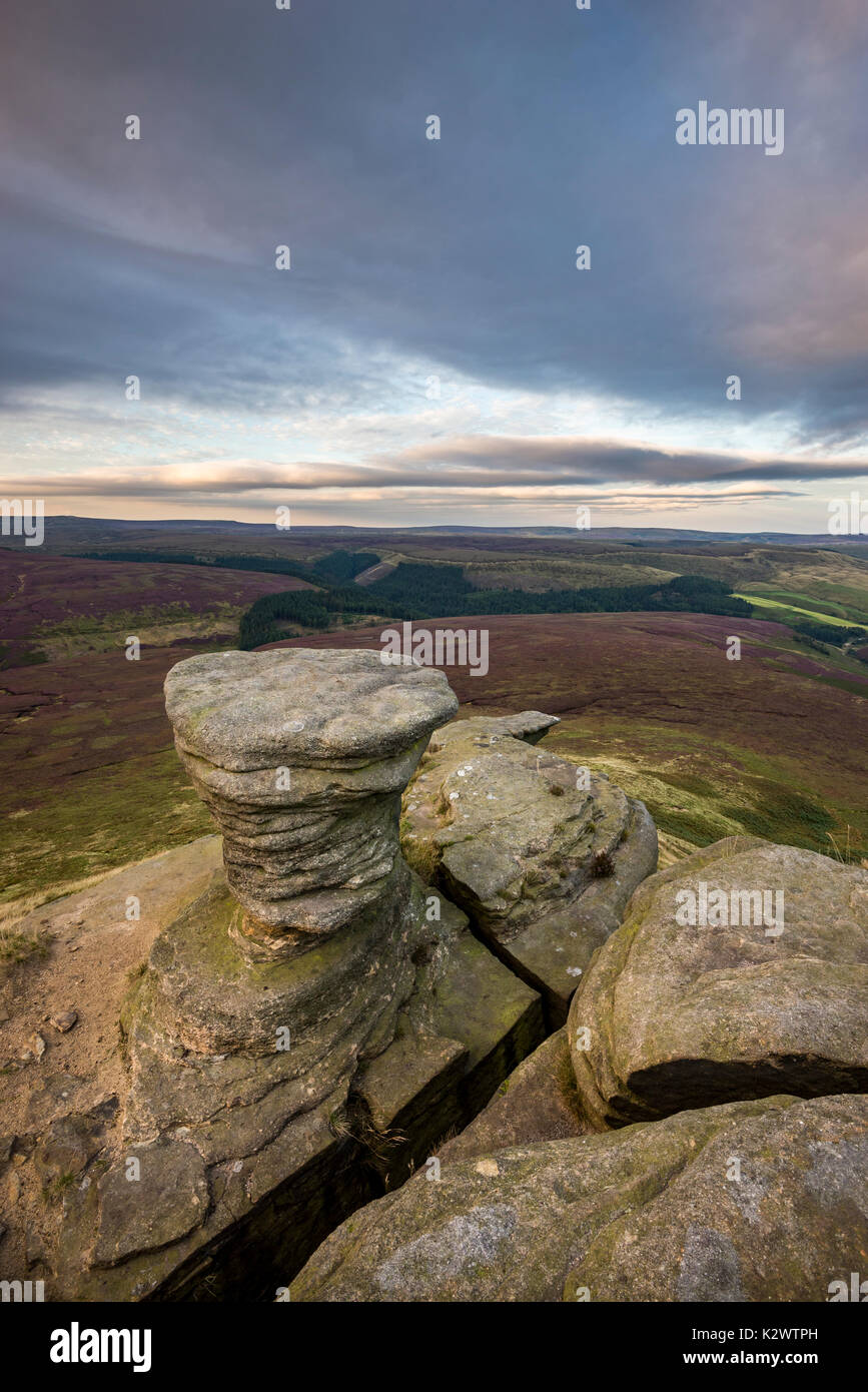Rock formation at Fairbrook Naze. Beautiful dusky colours in the moorland landscape below. Peak District, Derbyshire, England. Stock Photo