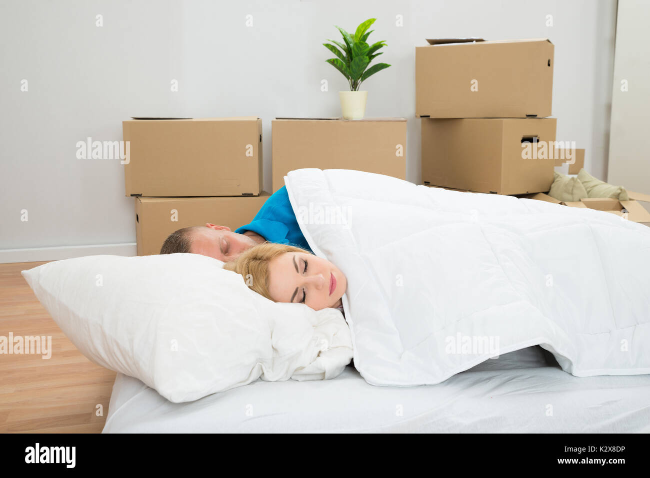 Young Couple Sleeping On Mattress In New Home Stock Photo